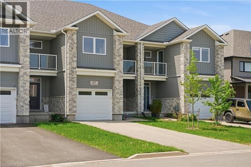 Contemporary townhome featuring stone and siding facade - 107 Stephenson Way, Palmerston, ON - Outdoor With Balcony With Facade