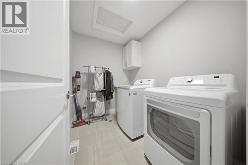 Laundry room featuring light-toned walls, tile flooring, and a white built-in cabinet - 107 Stephenson Way, Palmerston, ON - Indoor Photo Showing Laundry Room