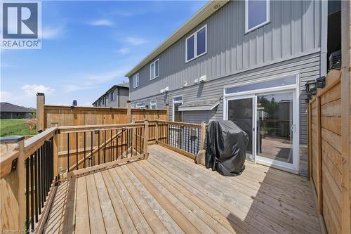Expansive wood deck with black metal balusters, privacy fencing, and direct access to the interior via a sliding glass door - 107 Stephenson Way, Palmerston, ON - Outdoor With Deck Patio Veranda With Exterior