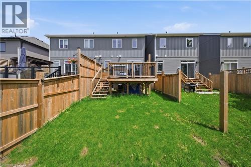 Fenced backyard featuring a wooden deck with railing, stairs, and a ground-level patio area - 107 Stephenson Way, Palmerston, ON - Outdoor With Deck Patio Veranda With Exterior