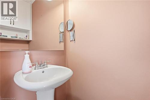 Pedestal sink with chrome faucet, complemented by a wall-mounted mirror - 86 San Remo Drive, Hamilton, ON - Indoor Photo Showing Bathroom