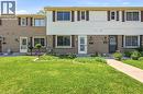 Two-story townhouse exterior featuring brick and siding facade, multiple windows with shutters, and a well-maintained front lawn with a concrete pathway - 86 San Remo Drive, Hamilton, ON  - Outdoor With Facade 