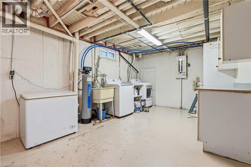 Basement utility space featuring exposed ceiling joists, concrete flooring, and a laundry area with a utility sink - 86 San Remo Drive, Hamilton, ON - Indoor Photo Showing Laundry Room