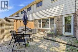 Paved patio area featuring brick and siding exterior - 