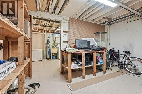 Basement area featuring exposed ceiling joists, concrete flooring, and built-in wood shelving - 86 San Remo Drive, Hamilton, ON - Indoor