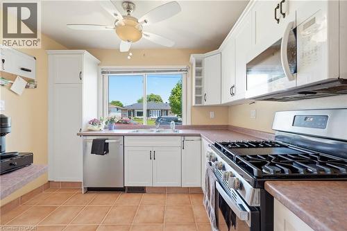 Kitchen featuring white cabinetry, brown countertops, and tile flooring - 86 San Remo Drive, Hamilton, ON - Indoor Photo Showing Kitchen With Double Sink