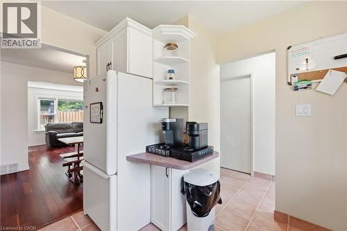 Kitchen area featuring white cabinetry, a built-in corner shelving unit, and tile flooring - 86 San Remo Drive, Hamilton, ON - Indoor