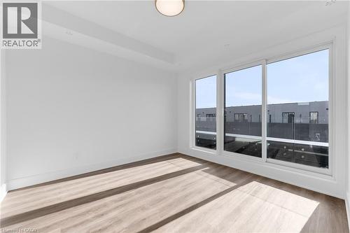 Bright interior space featuring a large three-panel sliding glass door with white frames - 146 Everett Common, St. Catharines, ON - Indoor Photo Showing Other Room