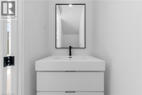Contemporary floating vanity with integrated sink, matte black faucet, and a sleek black-framed mirror - 146 Everett Common, St. Catharines, ON - Indoor Photo Showing Bathroom