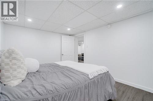 Bedroom featuring wood-finish flooring, white walls, and a drop ceiling with recessed lighting - 60 Lysanda Avenue, London, ON - Indoor Photo Showing Bedroom