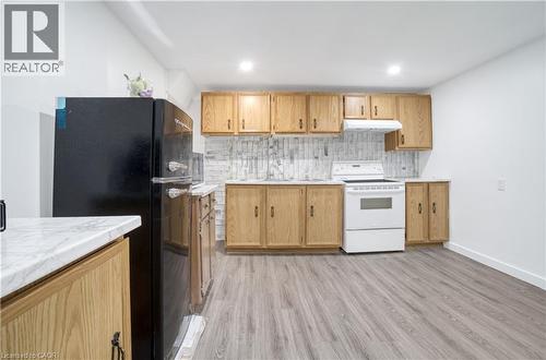Kitchen featuring wood cabinetry, white countertops, white tile backsplash, and a white range - 60 Lysanda Avenue, London, ON - Indoor Photo Showing Kitchen