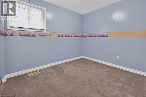 Carpeted room with a double-pane window featuring horizontal blinds - 186 Glenmor Drive, Caledonia, ON - Indoor Photo Showing Other Room