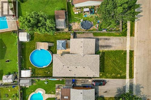 Aerial perspective highlighting a residential property with a shingled roof, a circular above-ground pool with a surrounding deck, and a shaded gazebo - 186 Glenmor Drive, Caledonia, ON - Outdoor With Above Ground Pool