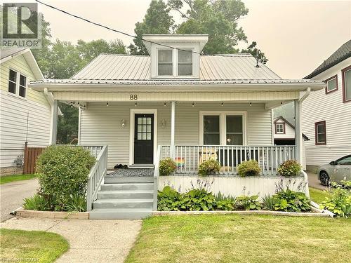 Light gray siding exterior with a metal roof and an upper dormer window - 88 Brook Street, Simcoe, ON - Outdoor With Deck Patio Veranda