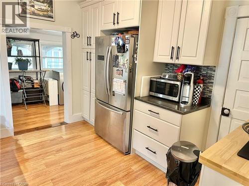 Kitchen featuring white shaker cabinetry, stainless steel refrigerator, dark countertops, and a mosaic tile backsplash - 88 Brook Street, Simcoe, ON - Indoor Photo Showing Kitchen