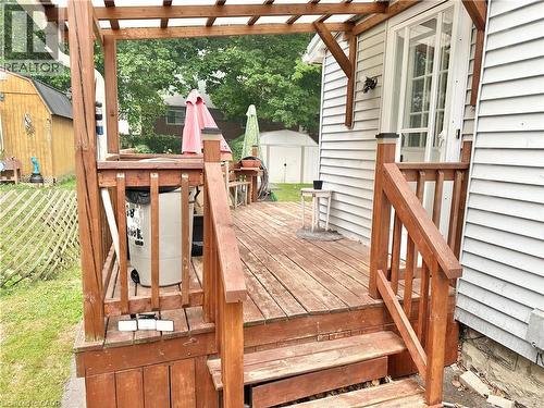 Wood-finish deck with pergola framing, featuring built-in railing, steps, and a glass-paneled exterior door - 88 Brook Street, Simcoe, ON - Outdoor