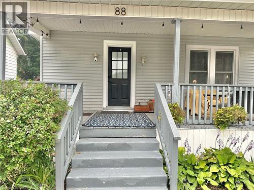 Front porch featuring a dark entry door with glass panes, light gray siding, and a contrasting white trim - 88 Brook Street, Simcoe, ON - Outdoor