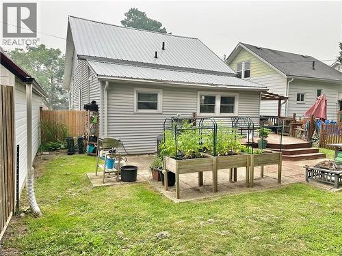 Backyard featuring a paver patio area with raised garden beds and a multi-level wood deck - 88 Brook Street, Simcoe, ON - Outdoor With Exterior
