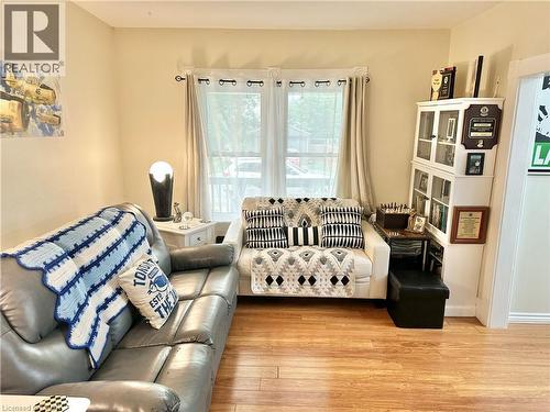 Living area featuring wood-finish flooring, a window with curtain rods, and a white display cabinet - 88 Brook Street, Simcoe, ON - Indoor Photo Showing Living Room