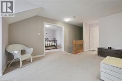 Carpeted flooring throughout, with a wood staircase railing and balusters - 