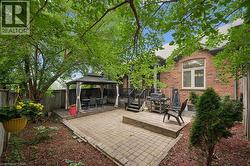 Private backyard featuring a paver patio and a raised wooden deck with a gazebo - 