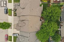 Residential property featuring a shingled roofline, multiple gables, and mature trees - 