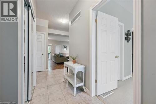 Foyer entry featuring ceramic tile flooring, a mirrored bi-fold closet, and white panel doors - 23 Knack Lane, Cambridge, ON - Indoor Photo Showing Other Room