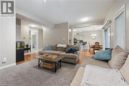 Carpeted living area with light-toned walls, wood-finish flooring, recessed lighting, and a sliding glass door - 23 Knack Lane, Cambridge, ON - Indoor Photo Showing Living Room