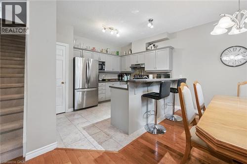 Kitchen featuring stainless steel appliances, light gray cabinetry, and a breakfast bar with seating - 23 Knack Lane, Cambridge, ON - Indoor Photo Showing Dining Room