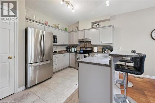 Kitchen featuring light gray cabinetry, stainless steel appliances, a breakfast bar, and tile flooring - 23 Knack Lane, Cambridge, ON - Indoor Photo Showing Kitchen
