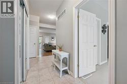 Foyer entry featuring ceramic tile flooring, a mirrored bi-fold closet, and white panel doors - 