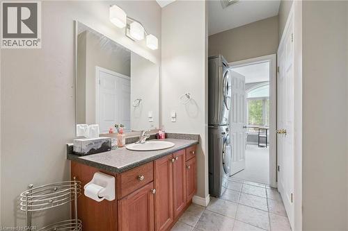 Vanity area featuring a wood-finish cabinet with a built-in sink, a wall-mounted mirror, and a three-light fixture - 23 Knack Lane, Cambridge, ON - Indoor Photo Showing Bathroom