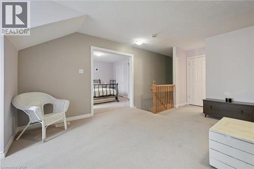 Carpeted flooring throughout, with a wood staircase railing and balusters - 23 Knack Lane, Cambridge, ON - Indoor Photo Showing Other Room