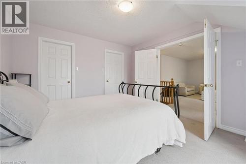 Interior space featuring light purple walls, a textured white ceiling, and light-colored carpet flooring - 23 Knack Lane, Cambridge, ON - Indoor Photo Showing Bedroom