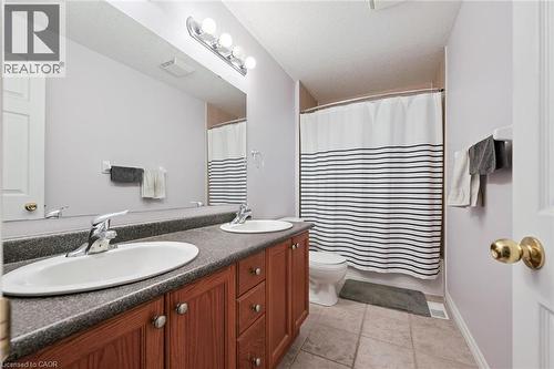 Bathroom featuring a double vanity with wood cabinetry and a dark countertop, a full-size mirror, and a shower-tub combination - 23 Knack Lane, Cambridge, ON - Indoor Photo Showing Bathroom
