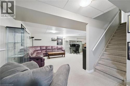 Carpeted staircase with white handrail leading to a carpeted lower level featuring an open-concept layout, recessed lighting, and a drop ceiling - 23 Knack Lane, Cambridge, ON - Indoor Photo Showing Other Room