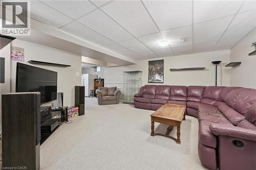 Finished recreation room featuring light-colored carpeting and a drop ceiling - 23 Knack Lane, Cambridge, ON - Indoor