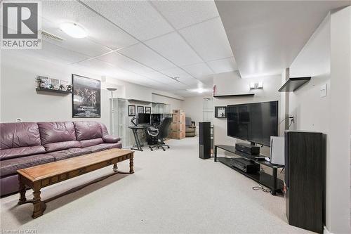 Carpeted recreation room featuring a drop ceiling with recessed lighting and a wall-mounted shelving unit - 23 Knack Lane, Cambridge, ON - Indoor