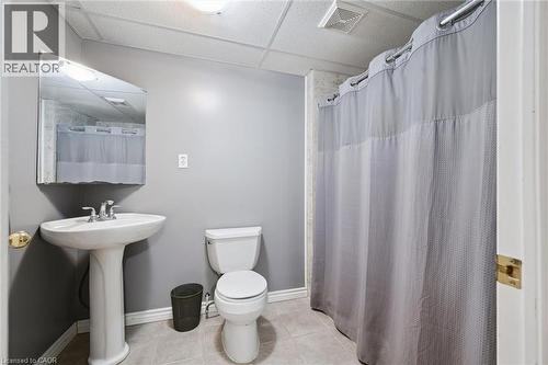 Full bathroom featuring a pedestal sink with a chrome faucet, a white toilet, and a shower area with a curtain rod - 23 Knack Lane, Cambridge, ON - Indoor Photo Showing Bathroom