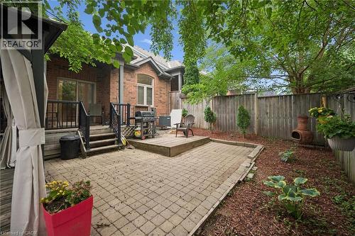 Private backyard featuring a large paver patio, elevated wood deck, and mature landscaping - 23 Knack Lane, Cambridge, ON - Outdoor