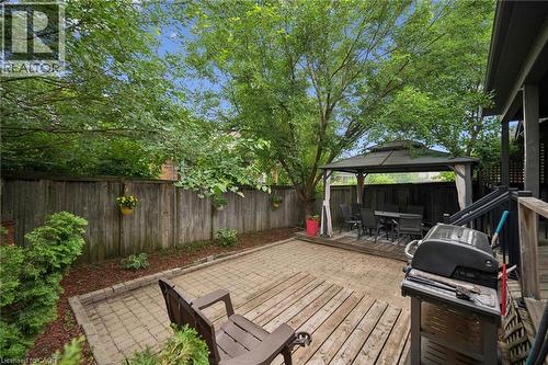 Private backyard featuring a fenced perimeter, a paved patio area, a raised wood deck, and an integrated gazebo structure - 23 Knack Lane, Cambridge, ON - Outdoor With Deck Patio Veranda