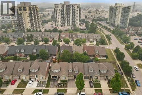 Residential neighborhood featuring a consistent architectural style across single-family homes, each with a private driveway, attached garage, and landscaped front yard - 23 Knack Lane, Cambridge, ON - 