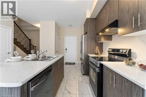 Modern kitchen featuring wood-grain cabinetry, light-toned countertops, and stainless steel appliances - 10 Lemon Avenue, Thorold, ON - Indoor Photo Showing Kitchen With Stainless Steel Kitchen With Double Sink