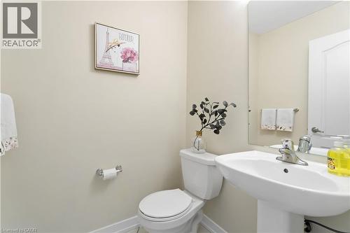 Powder room featuring a pedestal sink with chrome faucet, a toilet, and light-toned walls - 10 Lemon Avenue, Thorold, ON - Indoor Photo Showing Bathroom