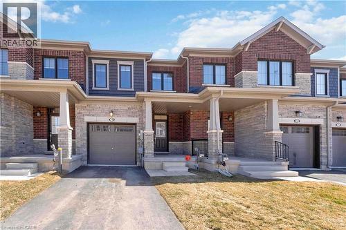 Contemporary brick and stone facade featuring a covered entry, single-car garage, upper-level windows, and a paved driveway - 10 Lemon Avenue, Thorold, ON - Outdoor With Facade
