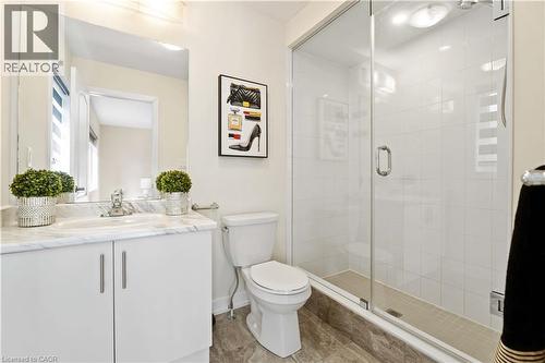 Bathroom featuring a glass-enclosed shower, white tile surround, and a vanity with a white countertop - 10 Lemon Avenue, Thorold, ON - Indoor Photo Showing Bathroom