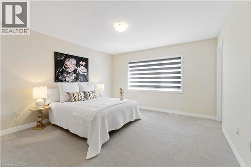Spacious room featuring neutral painted walls, light gray carpeting, and a window with horizontal blinds - 10 Lemon Avenue, Thorold, ON - Indoor Photo Showing Bedroom