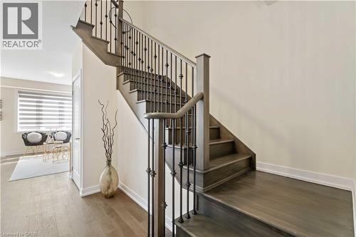 Hardwood staircase featuring dark wood-finish treads and risers, complemented by a black wrought iron baluster system - 10 Lemon Avenue, Thorold, ON - Indoor Photo Showing Other Room