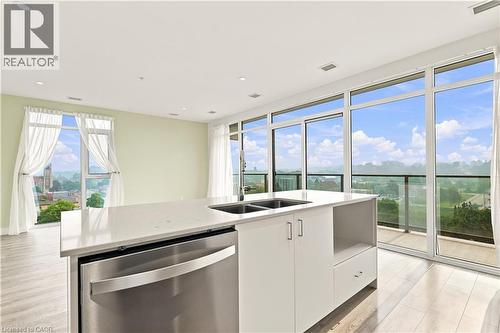 Kitchen island featuring a double-basin sink and integrated stainless steel dishwasher - 50 Grand Avenue S Unit# 713, Cambridge, ON - Indoor Photo Showing Kitchen With Double Sink