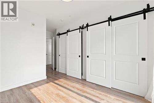 Modern white barn doors with black hardware - 50 Grand Avenue S Unit# 713, Cambridge, ON - Indoor Photo Showing Other Room